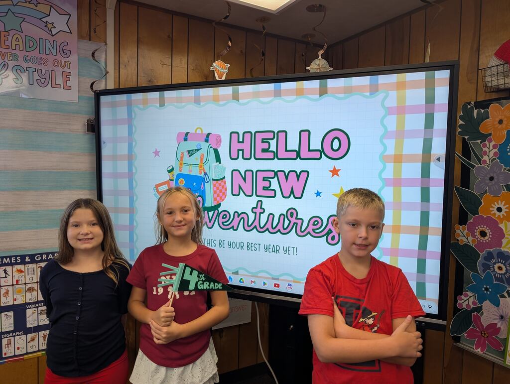 students standing in front of an interactive monitor 