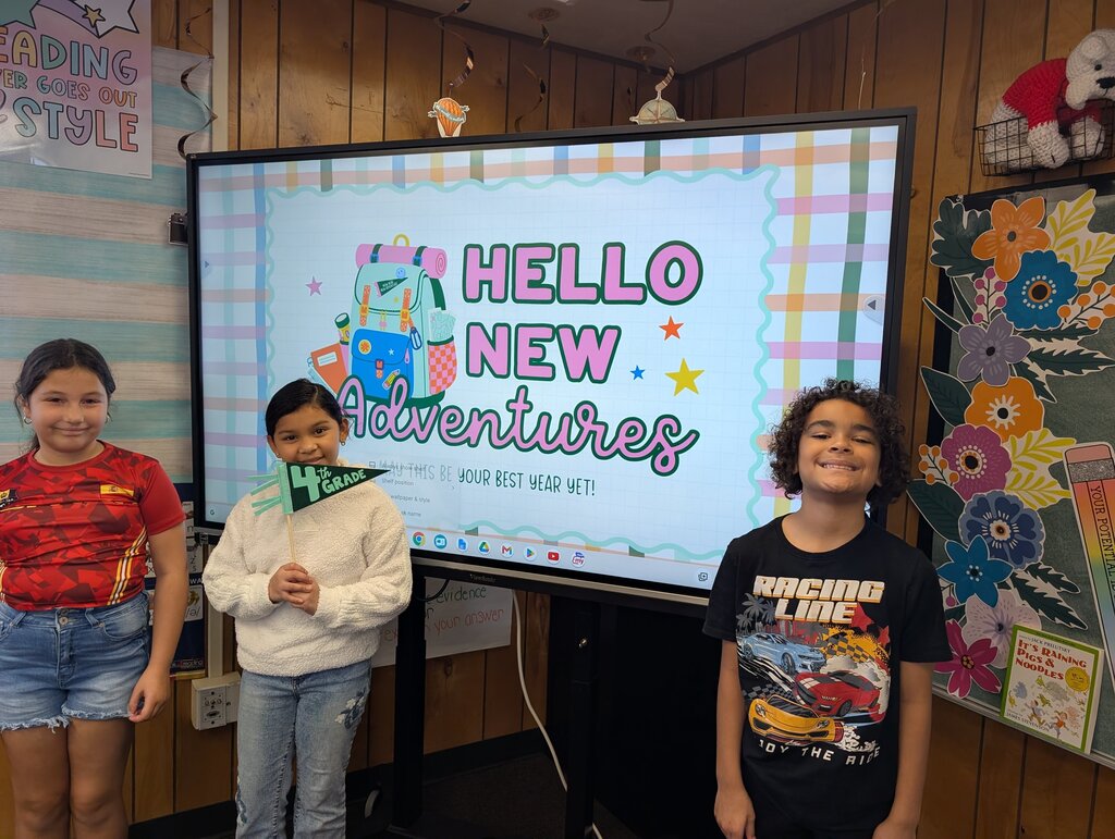students standing in front of an interactive monitor 