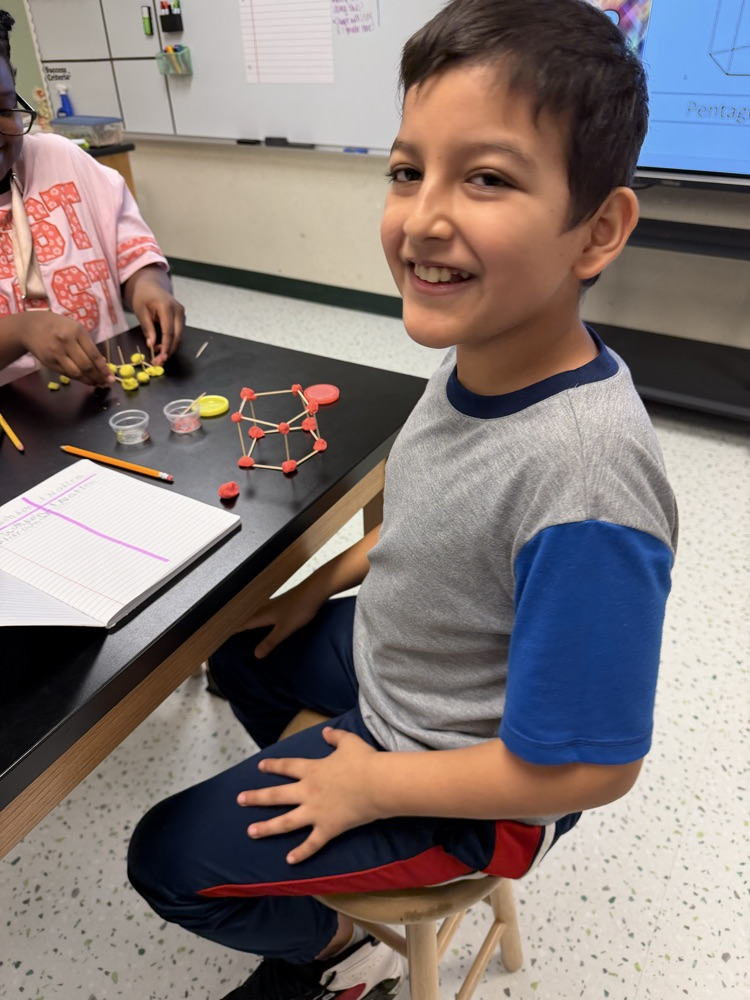 Students in their Science class working on their challenge of creating shapes using popsicle sticks and Play-Doh