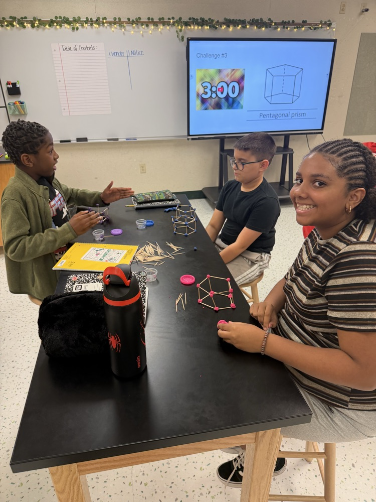Students in their Science class working on their challenge of creating shapes using popsicle sticks and Play-Doh