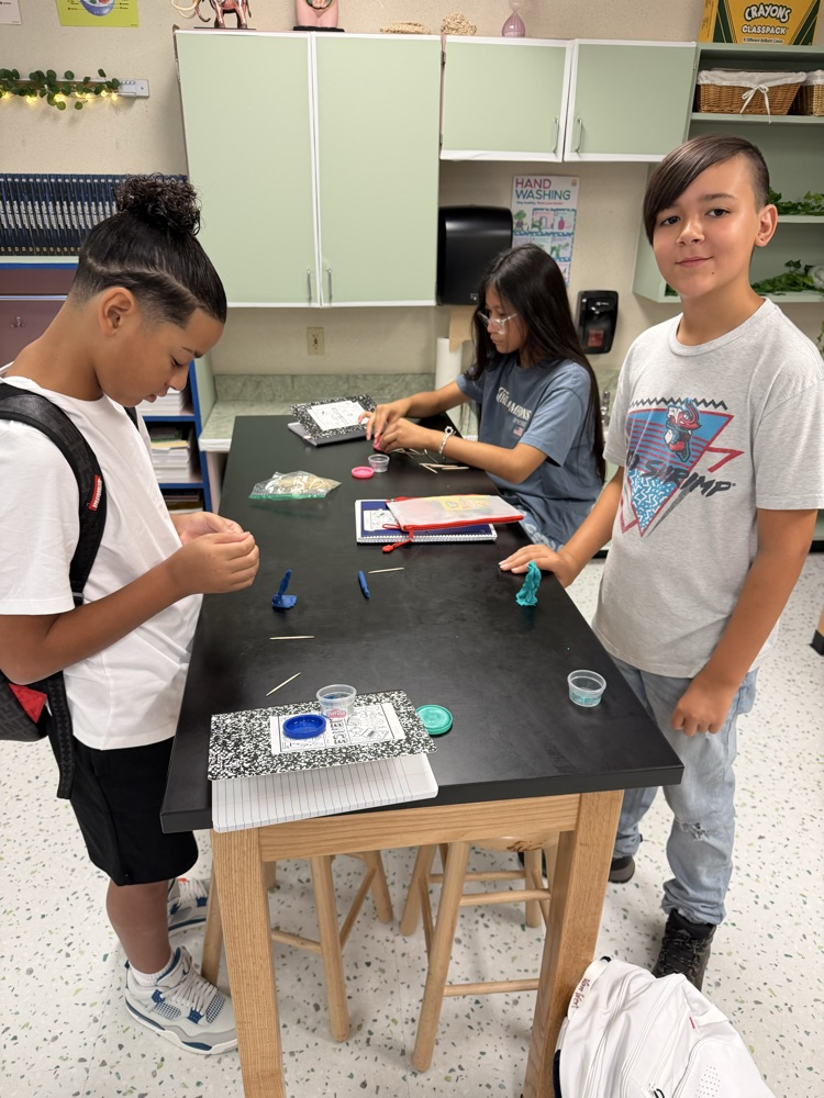 Students in their Science class working on their challenge of creating shapes using popsicle sticks and Play-Doh