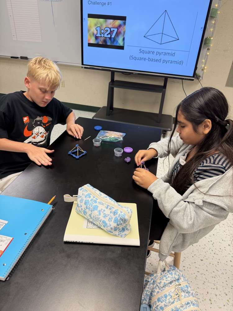 Students in their Science class working on their challenge of creating shapes using popsicle sticks and Play-Doh