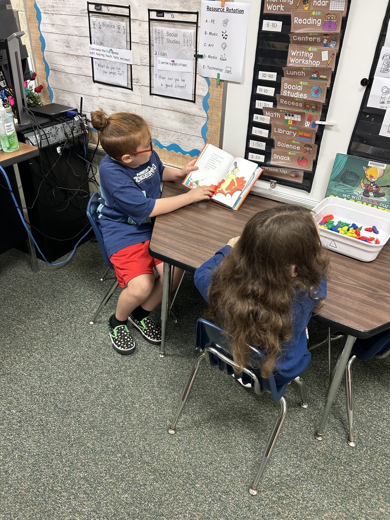 a student reading to another student