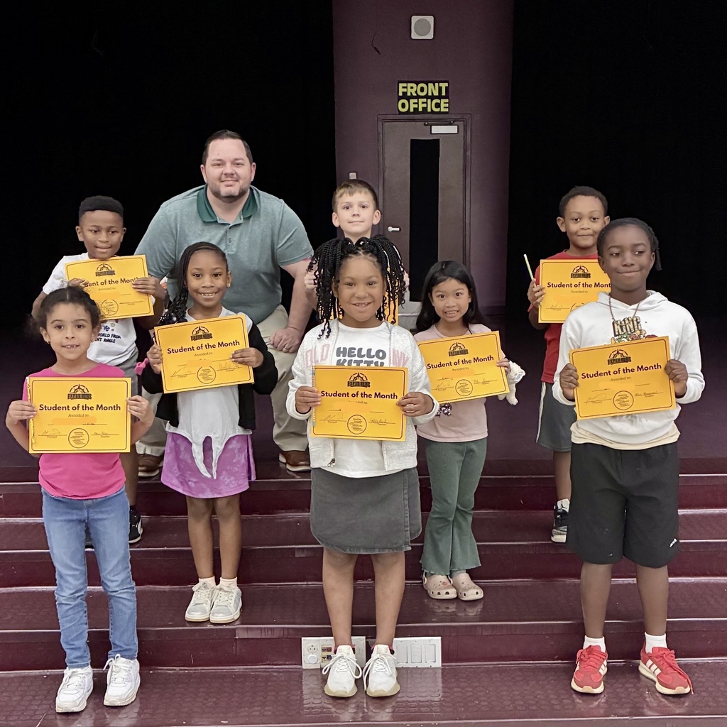 A group of students holding certificates stands on stairs, with Principal Martin at the back.