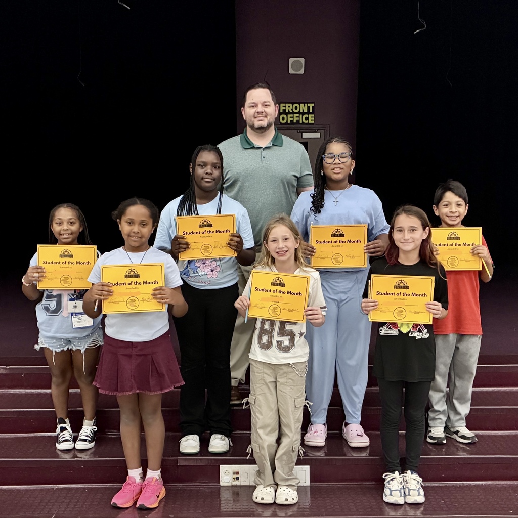 A group of students holding certificates stands on stairs, with Principal Martin at the back.
