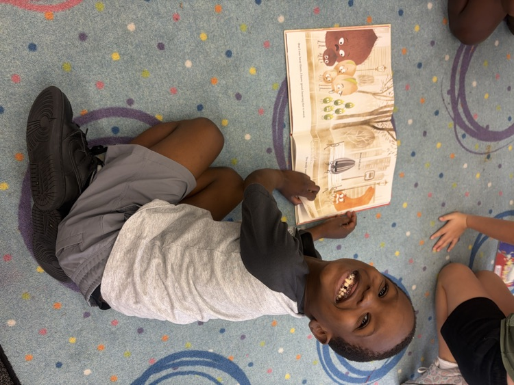 Students sitting on the carpet reading with partners