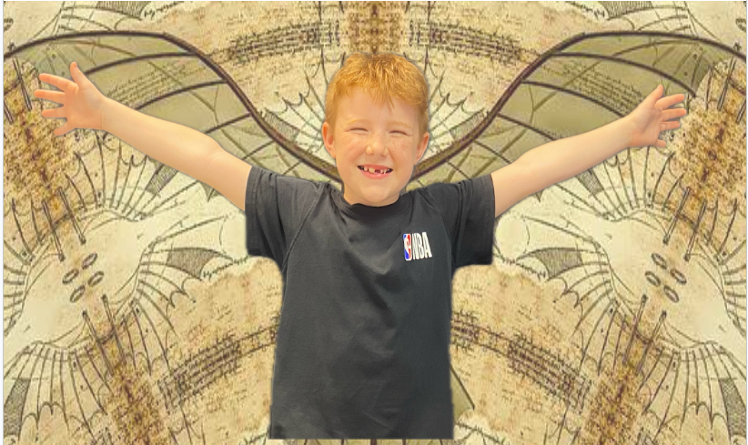 A young boy with red hair stands with arms outstretched in front of a patterned backdrop.