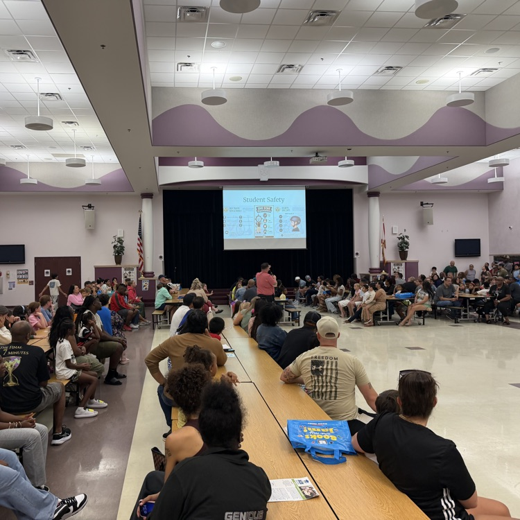 adults and students listening to a presentation from Mr. Martin