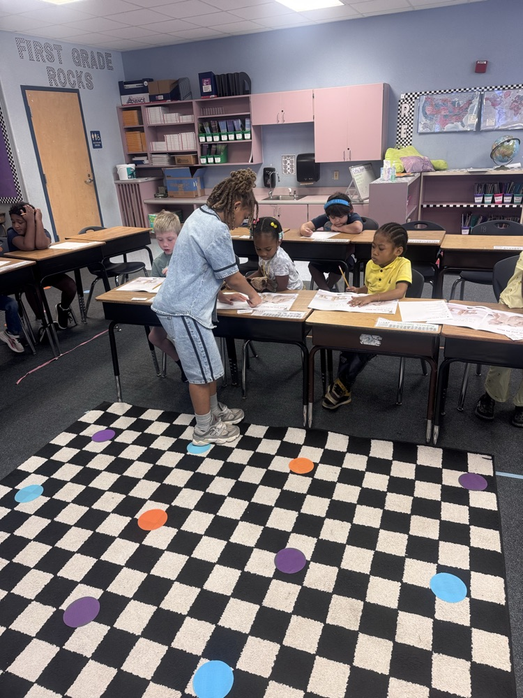 Student Leaders helping 1st Grade students in class