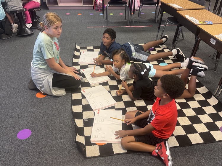 Student Leaders helping 1st Grade students in class