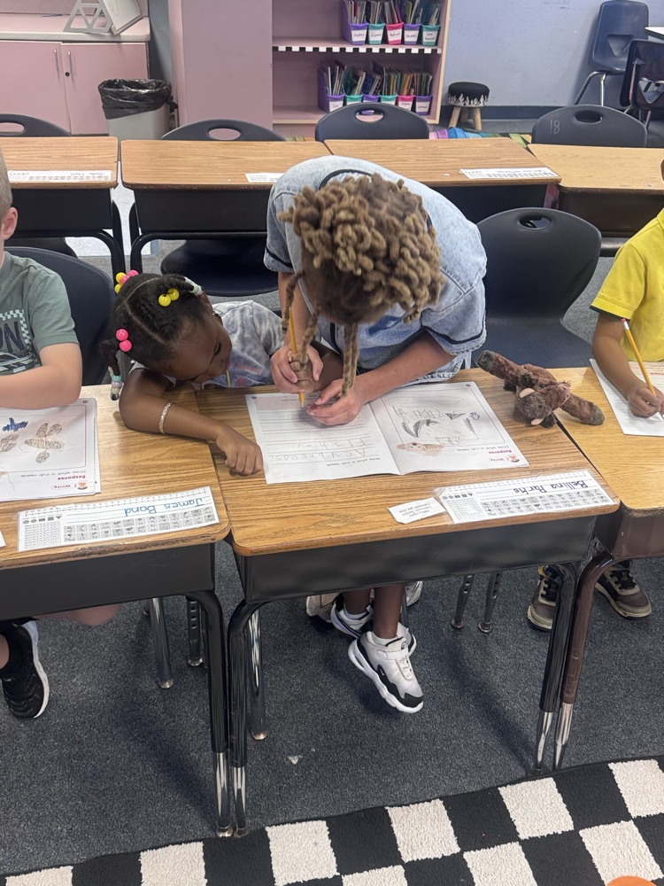 Student Leaders helping 1st Grade students in class