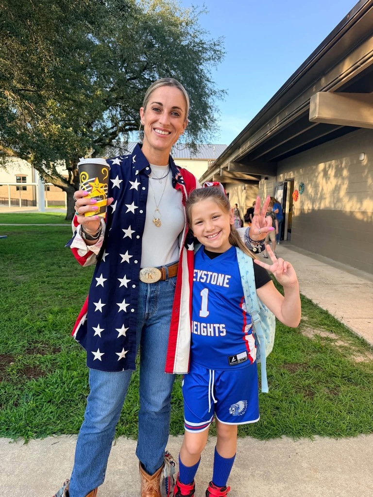 Woman and child standing outside. Child in a blue basketball uniform with the number 1 on it.