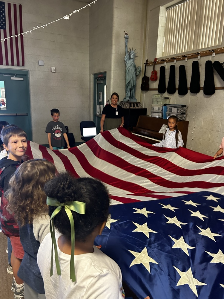 Mrs. Kibler in Music Class with the flag. 