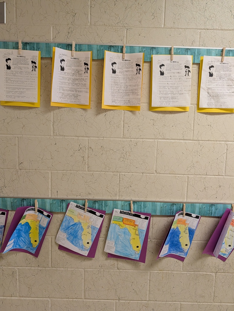 Display of papers on a blue bar with clips. Some are maps, others text. Brick wall in background.