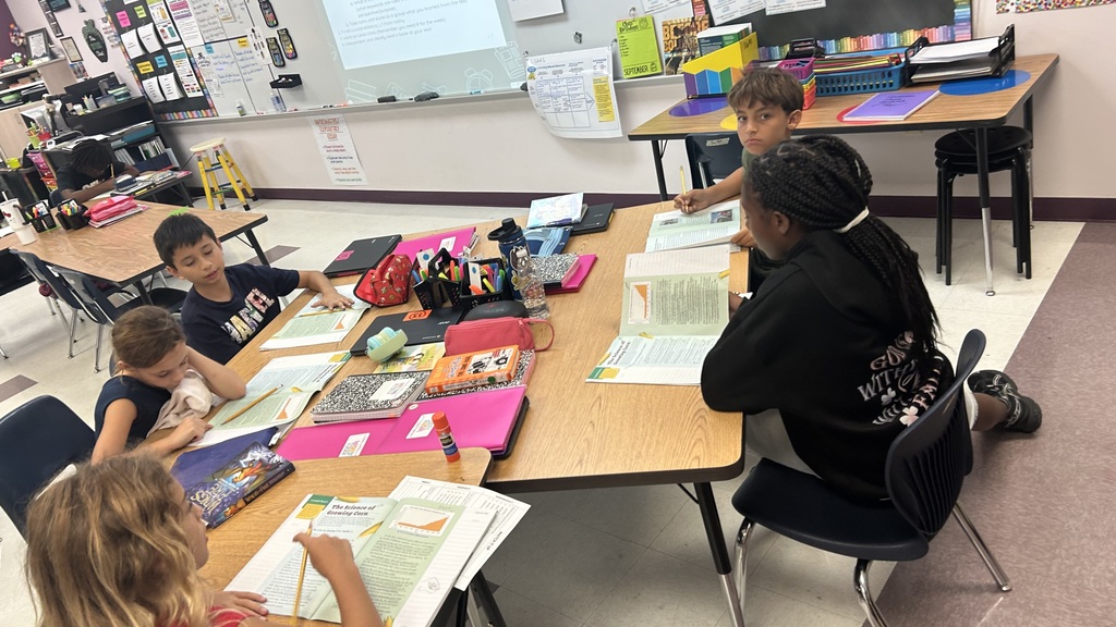A classroom with students working together seated at desks.