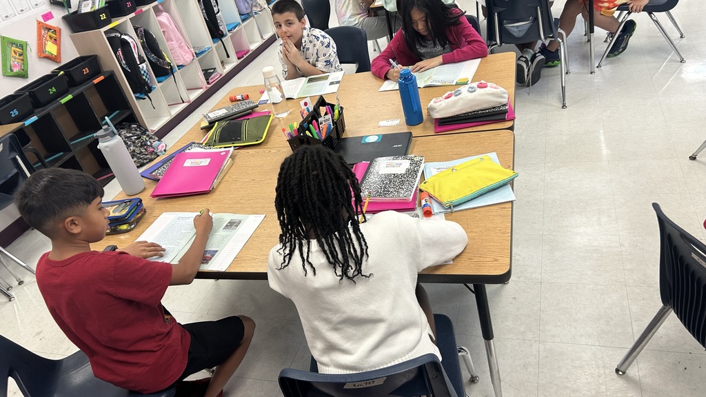 A classroom with four children seated around a table working together
