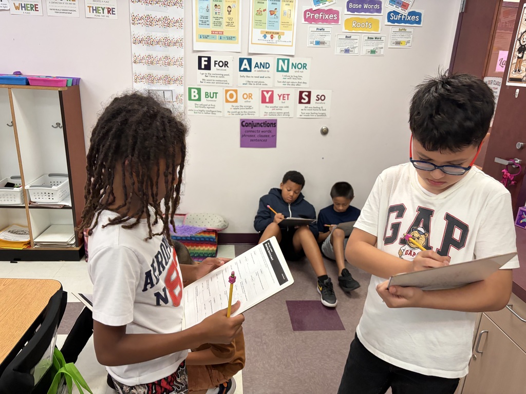Students holding papers and pencils work together