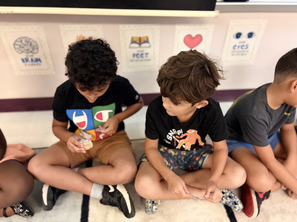 Students using a hand lens to observe rocks.