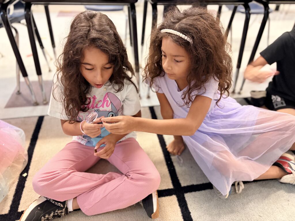 Students using a hand lens to observe rocks.