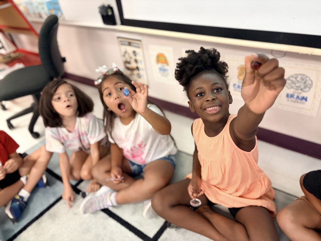 Students using a hand lens to observe rocks.