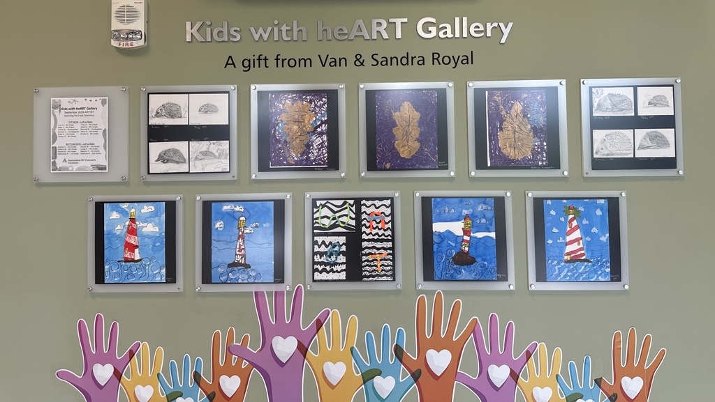 A wall with a Kids with beART Gallery title. Framed art is displayed, and handprints with hearts are below.