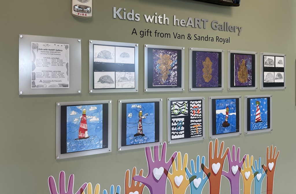 Artwork displayed on a wall. Each piece is framed and arranged. A banner reads, "Kids with heART Gallery."