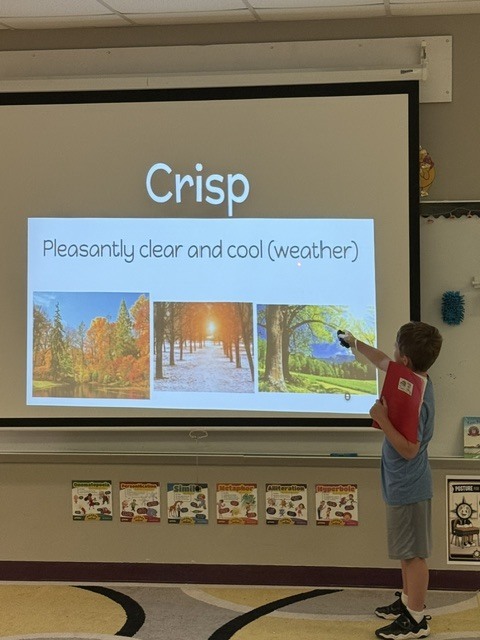 A child stands in front of a projector screen showing "Crisp" with images of clear, cool weather.