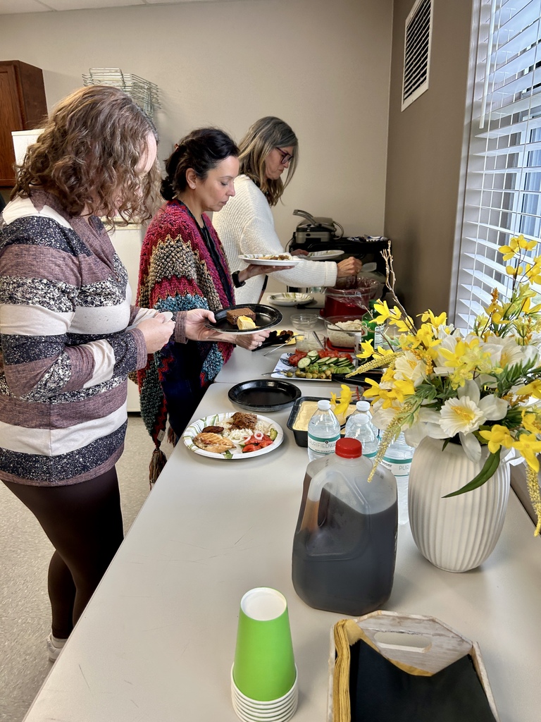 CVA staff members serve themselves from a buffet of homemade Cuban dishes prepared for the Teacher and School-Related Employee of the Year celebration.