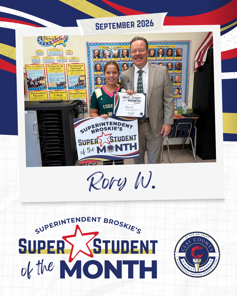 A girl and an adult hold a certificate in a classroom. They are surrounded by school decor.