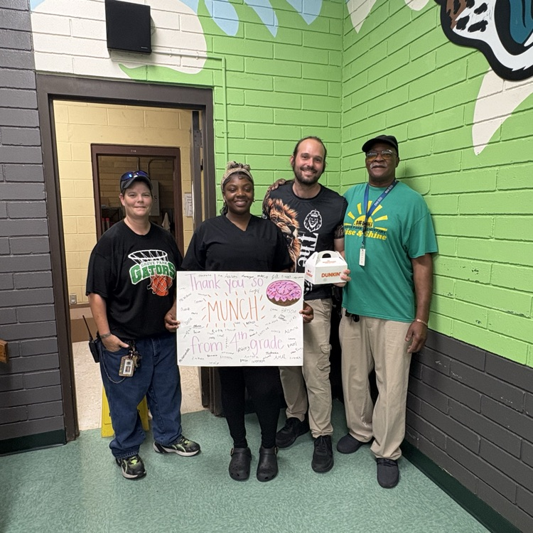 Custodial team posing with sign