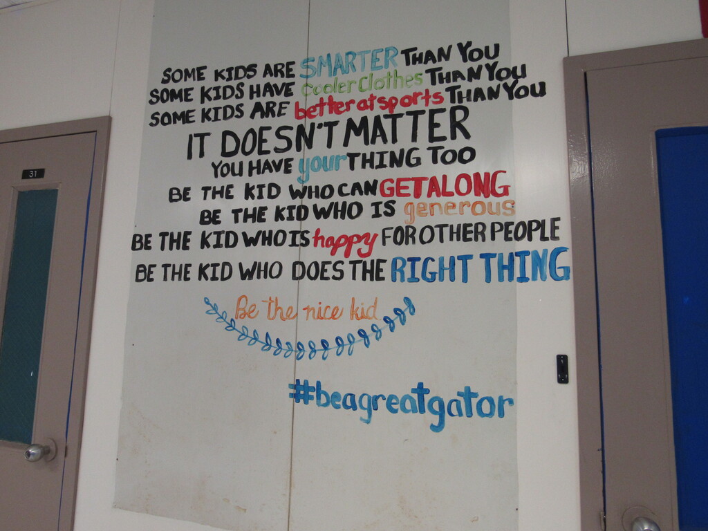 A white wall with a colorful mural. The mural features a series of statements about being a good person, framed by a blue border.