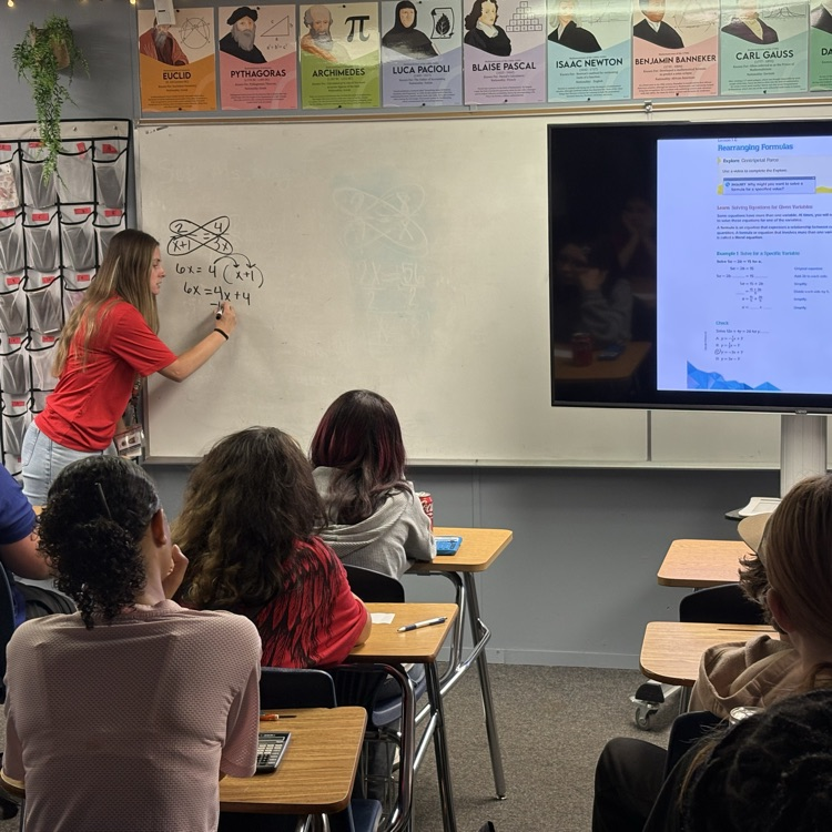 teacher at the board working through a problem