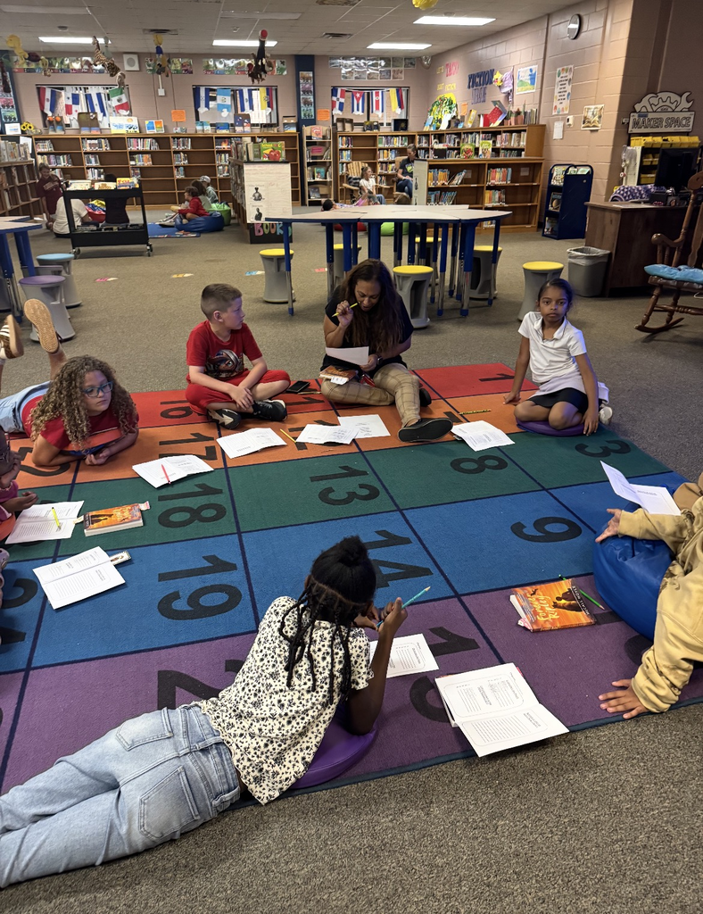 Students on a carpet with books and notebooks