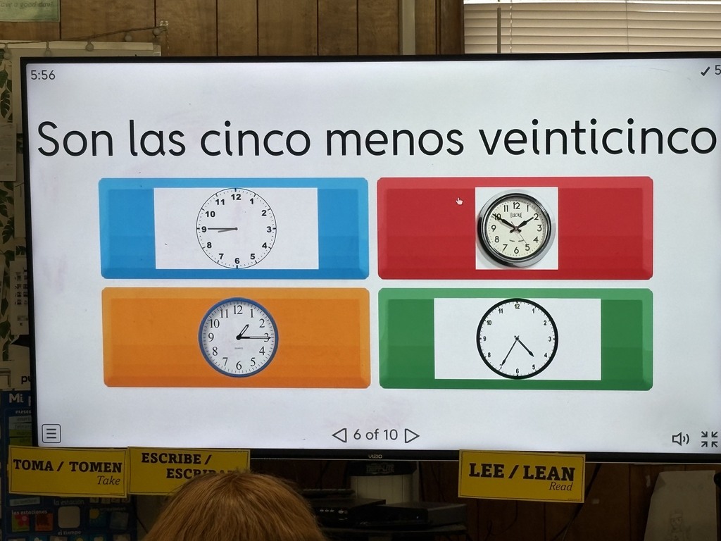 Display of four clocks set to different times. The display is on a screen with Spanish text above the clocks.