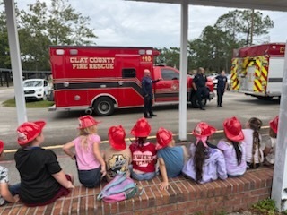 Ambulance truck in the parking lot with rescue people while students look on