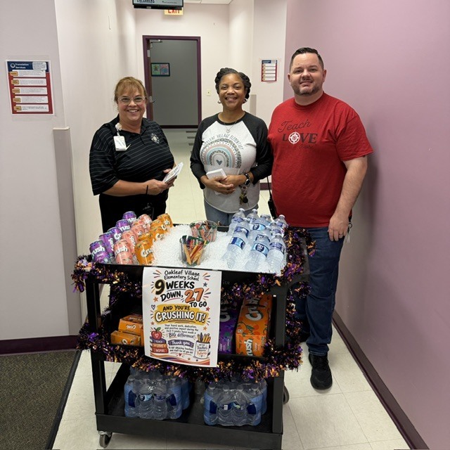OVE admin team pose with the drink cart and sign.