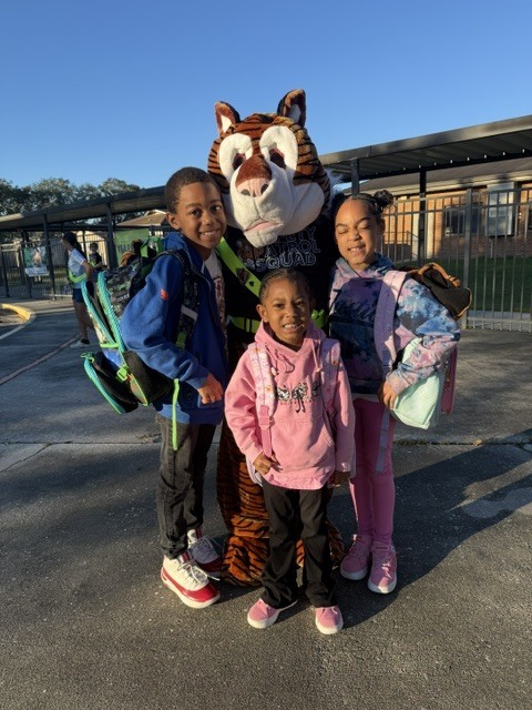 Children standing with tiger mascot