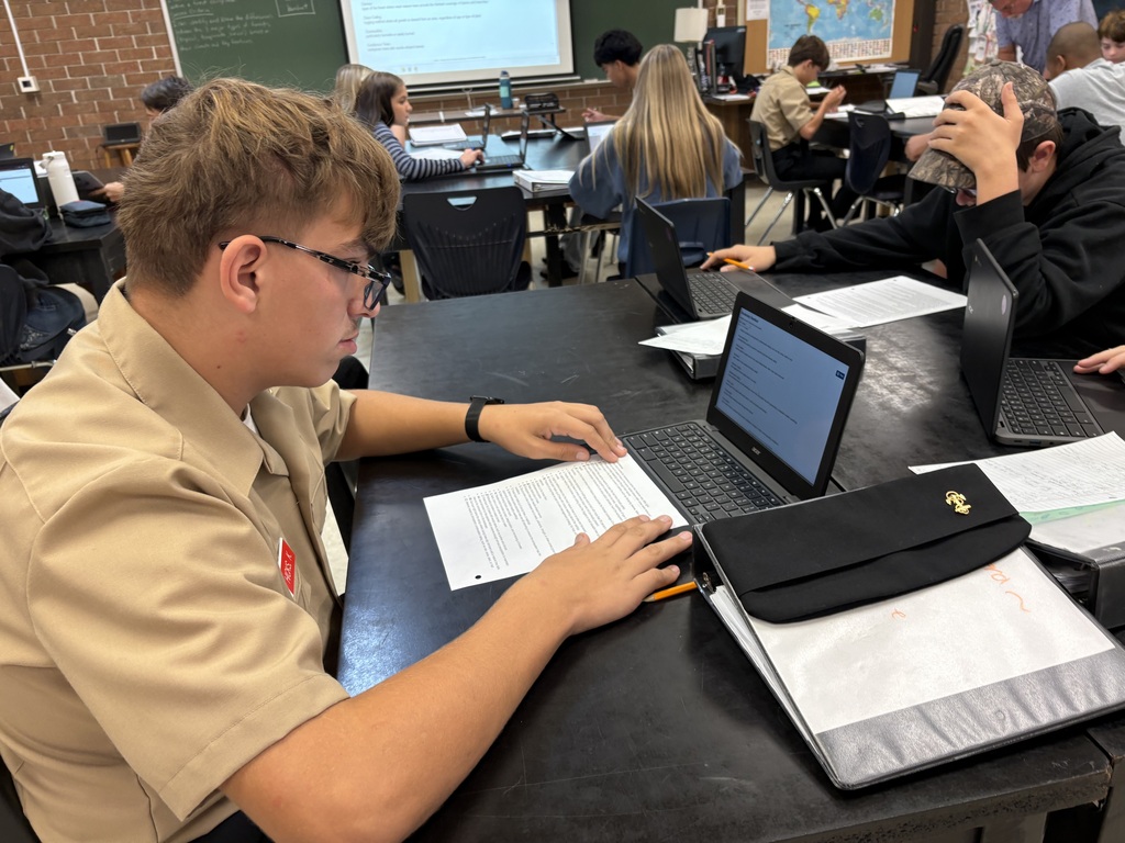 student working in a textbook and chromebook