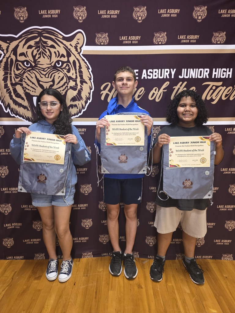 Three individuals, two females and one male, stand together holding certificates. Behind them, a tiger mascot is displayed on a dark background.
