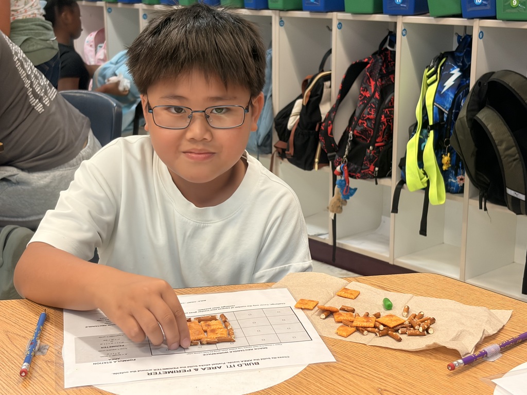 Student working on a math assignment with snacks.