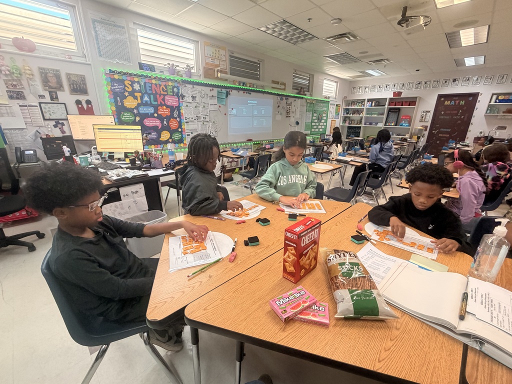 Students working on a math assignment with snacks.