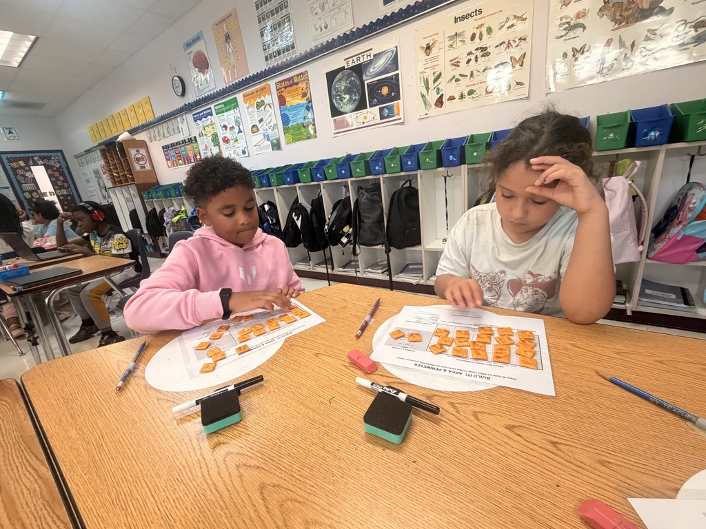 Students working on a math assignment with snacks.
