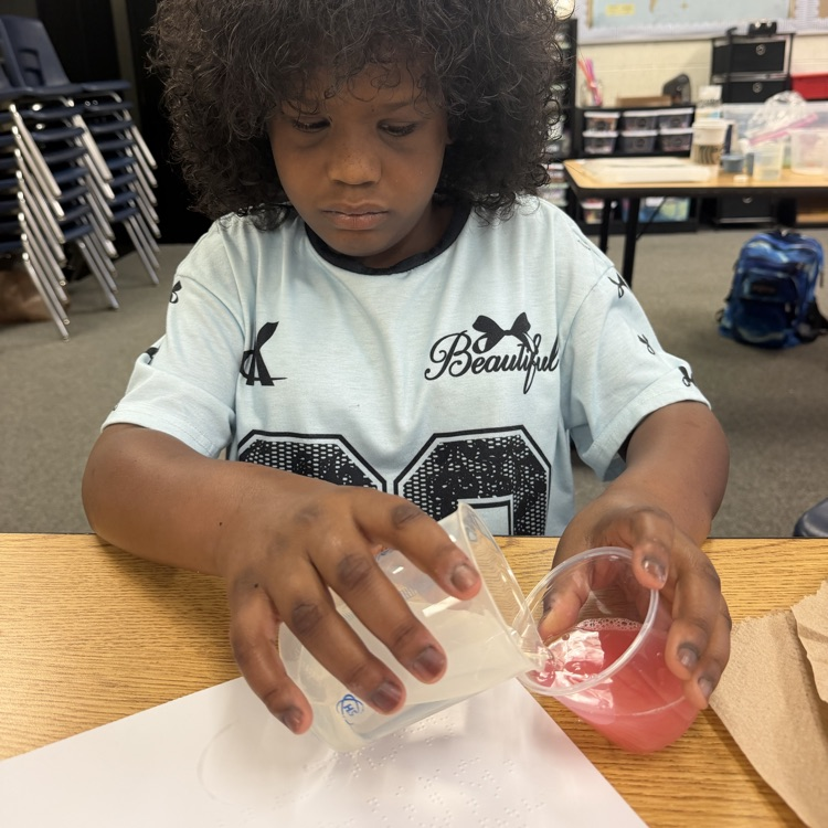 student pouring liquid