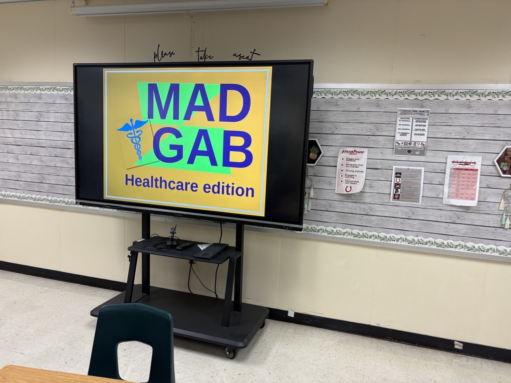 Monitor on a cart showing Healthcare Edition text; a chair and desk in the foreground.