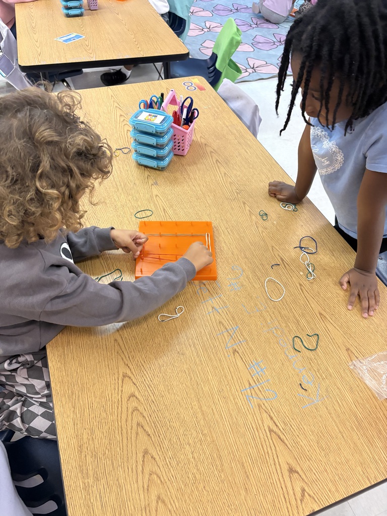 Students use rubber bands to build shapes on geoboards.