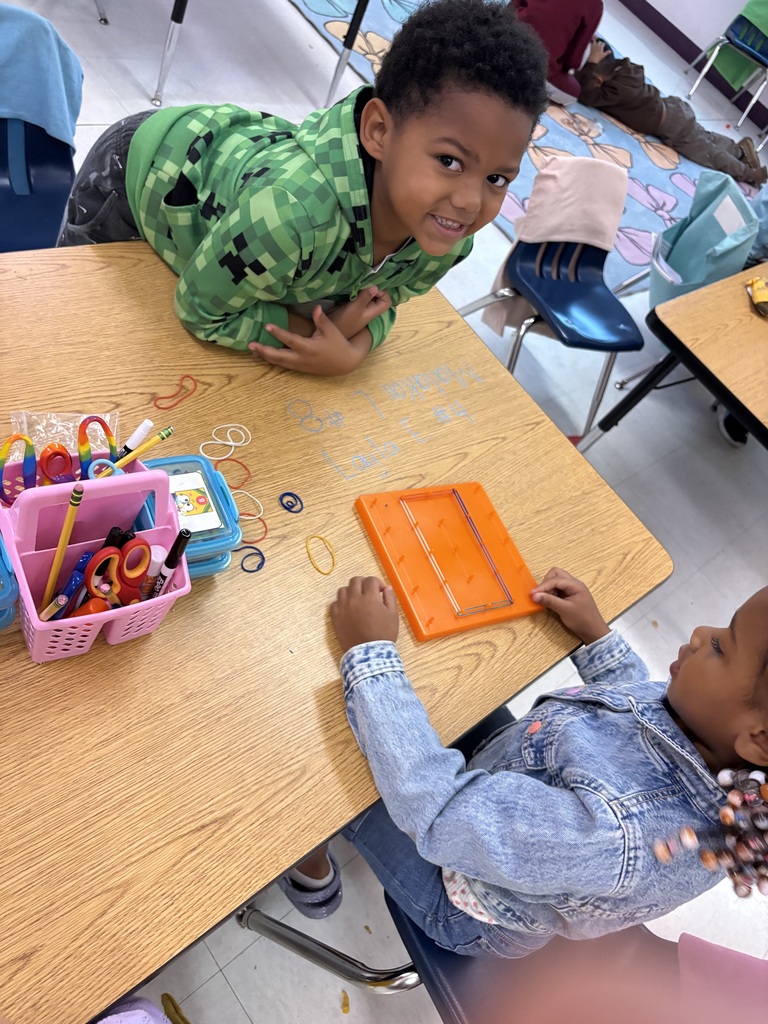 Students use rubber bands to build shapes on geoboards.