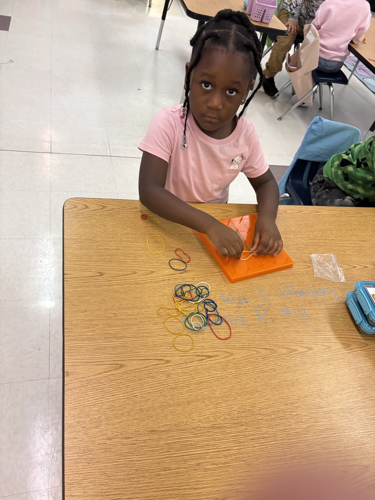 Students use rubber bands to build shapes on geoboards.