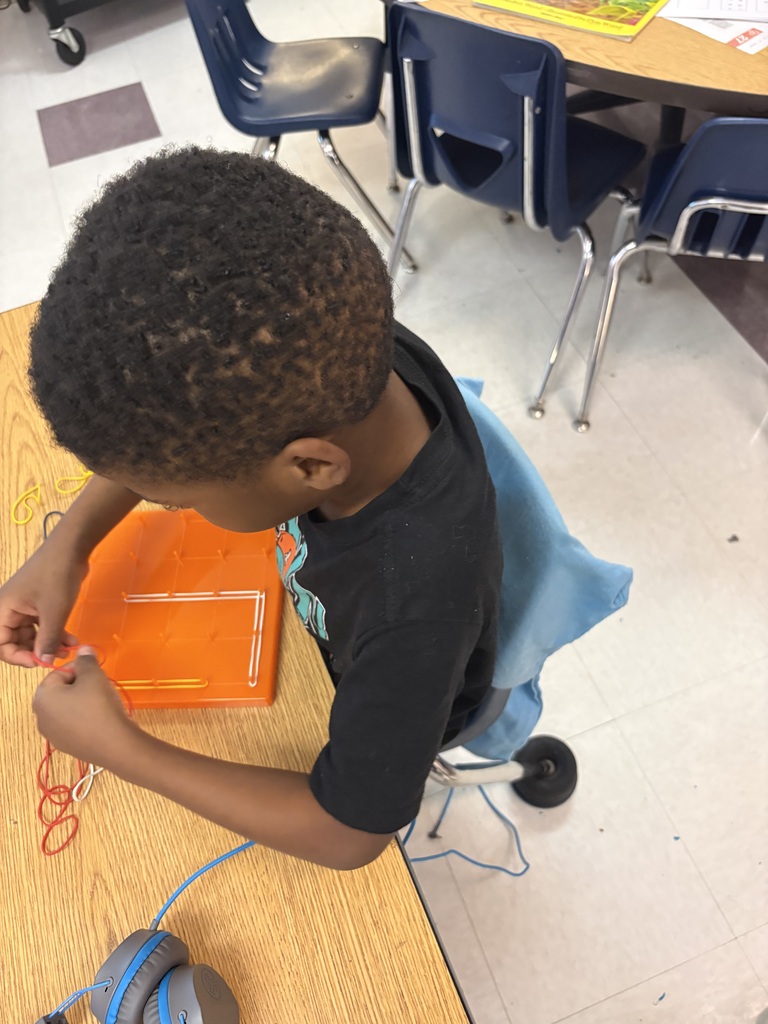 Students use rubber bands to build shapes on geoboards.