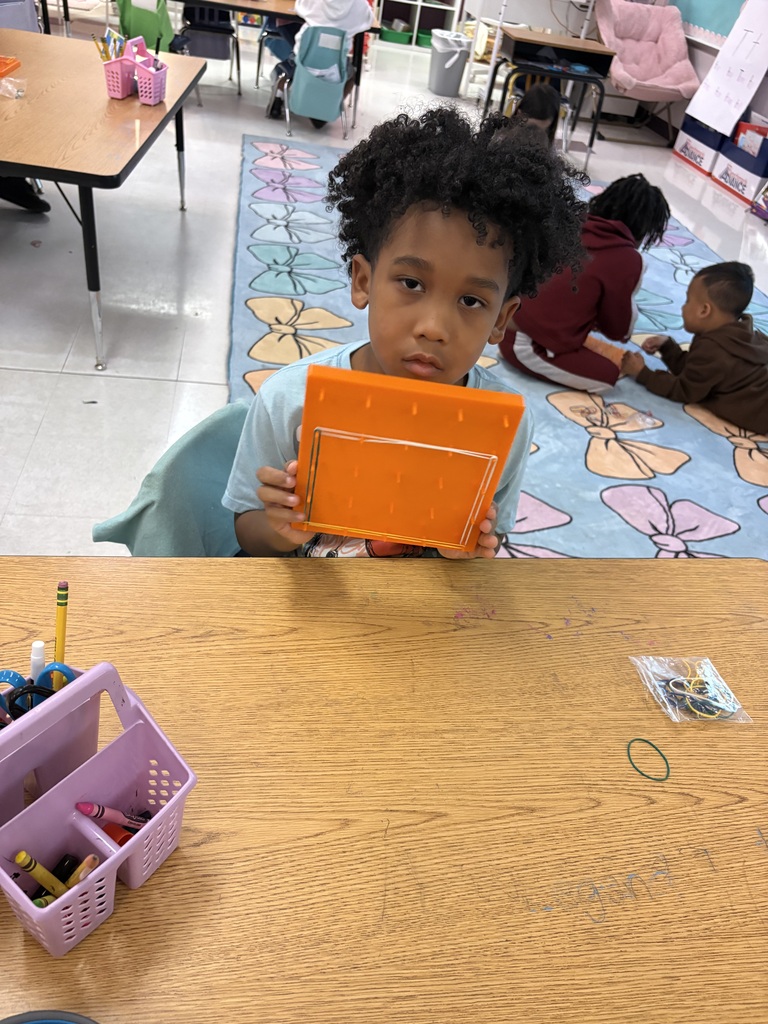 Students use rubber bands to build shapes on geoboards.