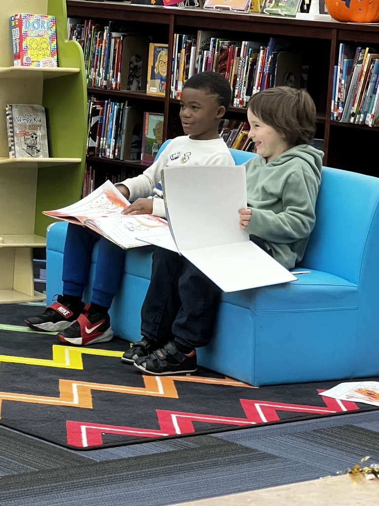 two young boys reading and laughing together